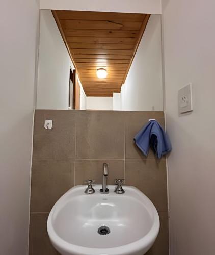 a bathroom with a white sink and a mirror at Copos de Nieve in El Bolsón