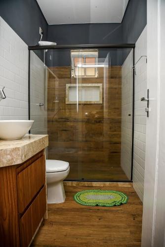 a bathroom with a shower and a toilet and a sink at Chácara no centro para até 15 pessoas com piscina aquecida e 5 quartos in Duas Barras
