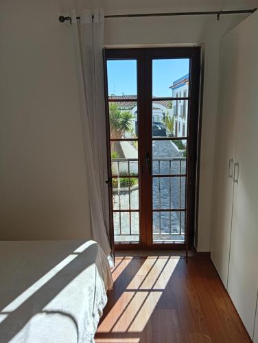 a bedroom with a bed and a large glass door at Casa próxima da praia fluvial in Mourão