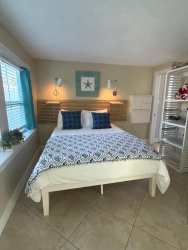 a bedroom with a large bed with blue pillows at Cozy Beach Rental 1B/1B in St Pete Beach