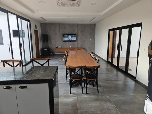 ein großer Konferenzraum mit einem langen Tisch und Stühlen in der Unterkunft Saltos Luxury - Quincho & Piscina in Salto del Guairá