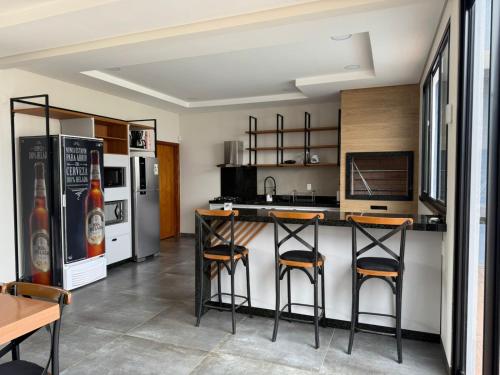 eine Küche mit Kühlschrank und Theke mit Hockern in der Unterkunft Saltos Luxury - Quincho & Piscina in Salto del Guairá