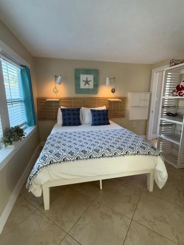 ein Schlafzimmer mit einem großen Bett mit blauen Kissen in der Unterkunft Cozy Beach Rental 1B/1B in St Pete Beach