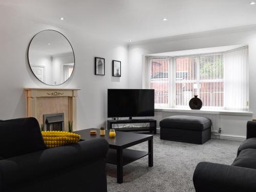 a living room with a couch and a tv and a mirror at West Street House in Southport