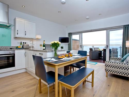 eine Küche und ein Wohnzimmer mit Tisch und Stühlen in der Unterkunft Curlew 4 - The Cove in Brixham