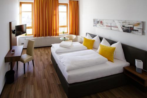 ヴェルスにあるHealth Vital Comfort Guestroomsの白いベッドと黄色い枕が備わるホテルルームです。
