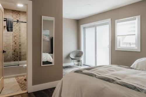 ein Schlafzimmer mit einem Bett und ein Badezimmer mit Dusche in der Unterkunft Swan Pond Cabin Hot Tub & Firepit Retreat in Swan Lake