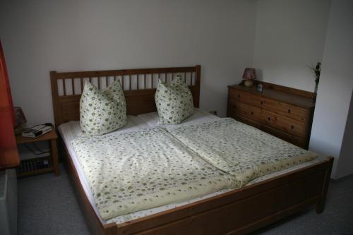 1 dormitorio con cama de madera y almohadas en Ferienwohnung Paul en Pirna