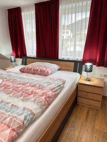 a bedroom with a bed with red curtains at Lisingtal Premium SUPER-COSY Rooms in Hinterlainsach
