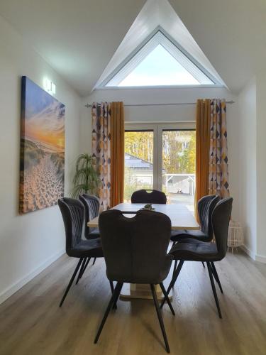 a dining room with a table and chairs and a large window at Zimmervermietung Voth in Wismar