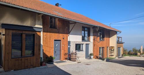 a house with wooden doors on the side of it at Domaine de la Griffe-maison mitoyenne Cou in La Roche-sur-Foron