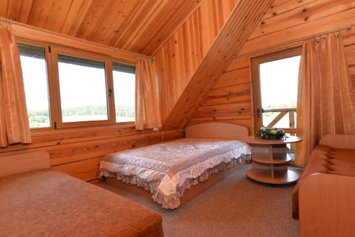 a bedroom with a bed in a log cabin at Romo sodyba in Trakai