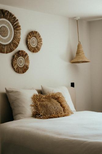 um quarto com uma cama branca com pratos decorativos na parede em B&B Zuidhoute em Maldegem