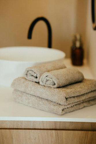 a pile of towels sitting on a counter next to a sink at B&B Zuidhoute in Maldegem