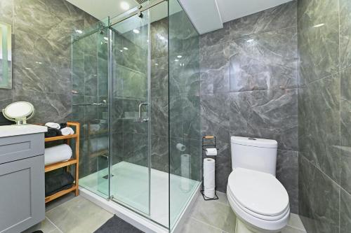 Un baño con inodoro y ducha de cristal. en SPACIOUS FULLY PRIVATE 2BR UNIT ON GROUND LEVEl, en Burlington
