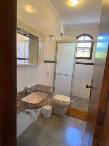 a bathroom with a sink and a toilet and a shower at Sobrado Guaratuba 3 quartos in Guaratuba