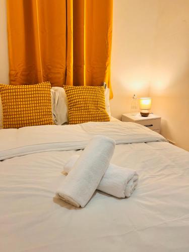 a white bed with two towels on top of it at The Brick Lane Suites London in London