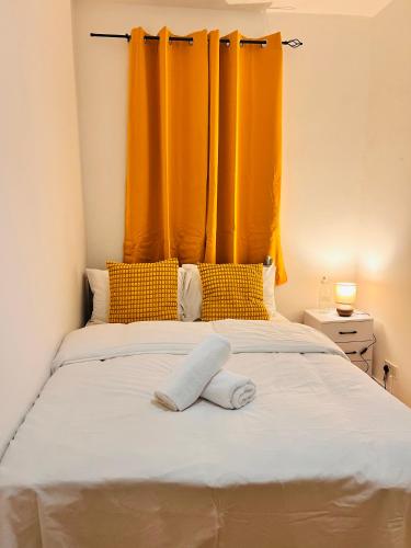 a bed with an orange curtain above it at The Brick Lane Suites London in London