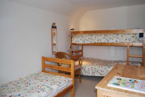 ein Schlafzimmer mit zwei Etagenbetten und einem Tisch in der Unterkunft Hof Rüsch - Bredensteen in Kesdorf