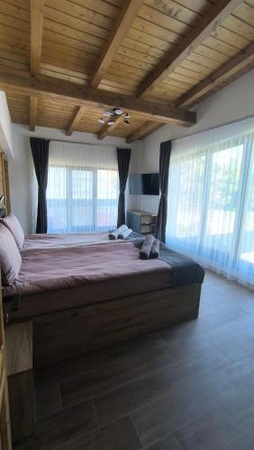 a large bedroom with a large bed with windows at Къщи за гости Авена и Авена 2 in Banya