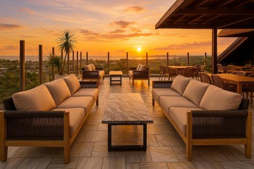 a living room with couches and tables and a sunset at Anaya Hotel Canggu in Canggu