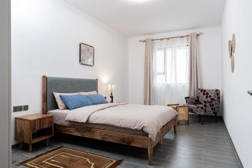 une chambre avec un lit, une chaise et une fenêtre dans l'établissement Diamond Ivy Two Bedroom Apartment, Swimming pool, gym, workspace ,Wonderiss Homes Kileleshwa Living, à Nairobi