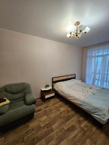 a bedroom with a bed and a couch and a chair at Яровиця 61 in Lutsk