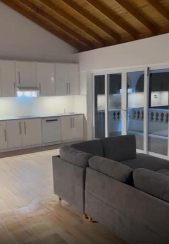 ein Wohnzimmer mit Couch und Küche in der Unterkunft Hibiscus Haven in Roseau