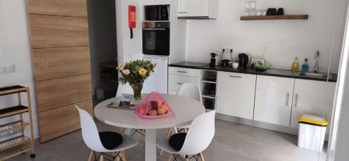 a kitchen with a table with a bowl of fruit on it at Quinta da pêra rocha in Alcobaça