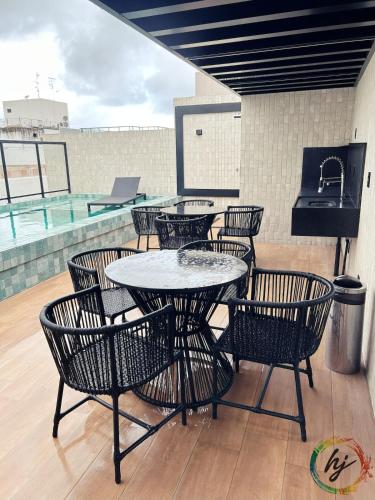 a patio with a table and chairs and a pool at Mares 502 in Tambaú
