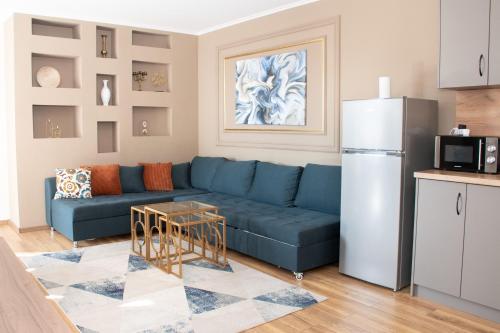 een woonkamer met een blauwe bank en een koelkast bij Gondola Apartments Lux in Bansko