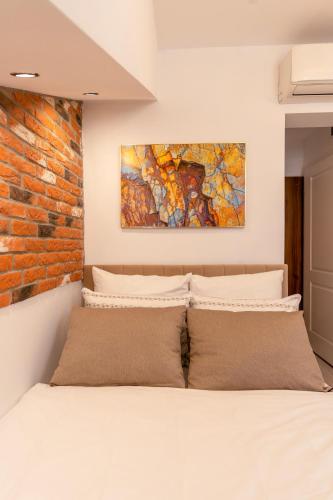a bed in a bedroom with a brick wall at Kazimierz Residence Apartments Parking - by Staymoovers in Krakow