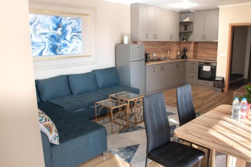een woonkamer met een blauwe bank en een keuken bij Gondola Apartments Lux in Bansko