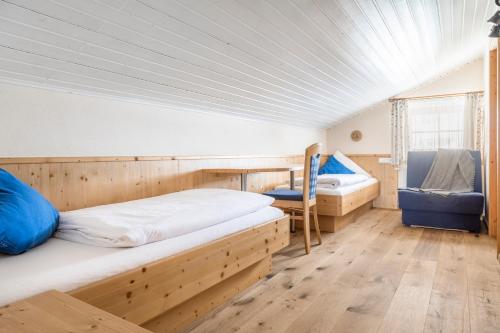 a bedroom with two bunk beds and a chair at Haarlehenhof in Grossarl