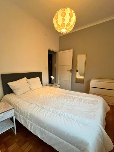 a bedroom with a large white bed and a chandelier at Good end Oporto View in Porto