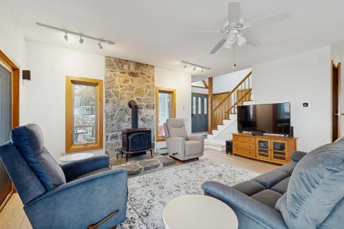 a living room with two blue chairs and a fireplace at Broadlake in Thayer Beach