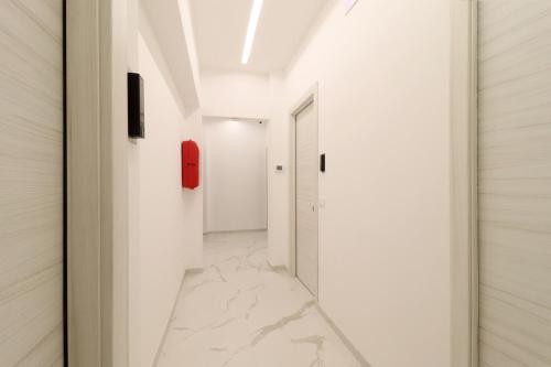 a hallway with white walls and a red phone on the wall at b&b la cattedrale in Avezzano