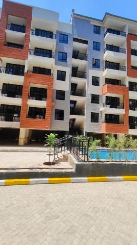ein großes Apartmenthaus vor einem Gebäude in der Unterkunft One Bedroom Apartment near KSG - Arc II in Nairobi