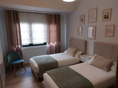 ein Hotelzimmer mit zwei Betten und einem Fenster in der Unterkunft Apartamento Puerta de San Fernando in Lugo