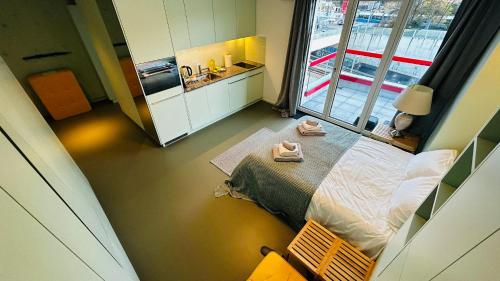 Una pequeña habitación con una cama y un lavabo. en Modern Living, Luxe Studio Zurich, en Zúrich