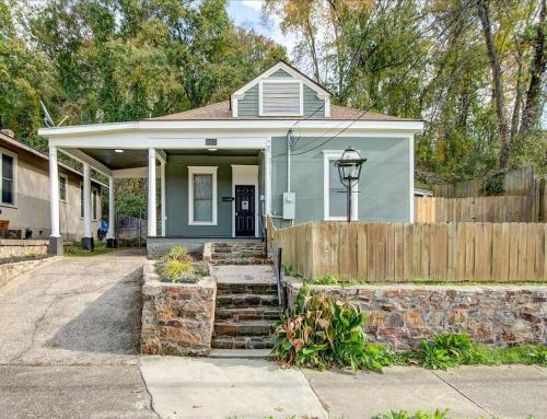 a small blue house with a wooden fence at Modern Park Avenue Cottage in Hot Springs in Hot Springs