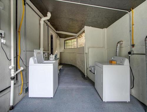 ein Badezimmer mit zwei Waschbecken und zwei Waschmaschinen darin in der Unterkunft Modern Park Avenue Cottage in Hot Springs in Hot Springs