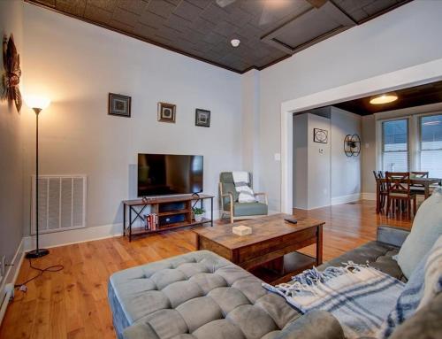 a living room with a couch and a table at Modern Park Avenue Cottage in Hot Springs in Hot Springs