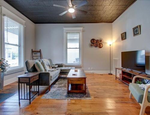 a living room with a couch and a tv at Modern Park Avenue Cottage in Hot Springs in Hot Springs