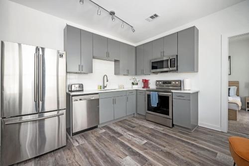 eine Küche mit grauen Schränken und Geräten aus Edelstahl in der Unterkunft Luxury 5Beds 3Baths 2Balcony Penthouse 542Blvd in Atlanta