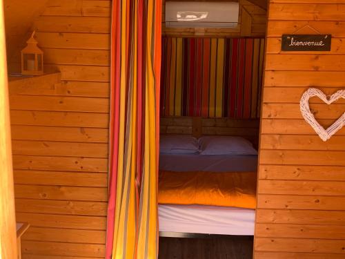 una camera da letto con un letto in una cabina di legno di Barrel Orange a Saint-André