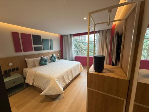 een slaapkamer met een groot bed en een spiegel bij Hotel More By Kavia in Mexico-Stad