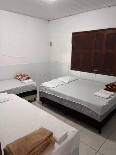 a room with two beds and a cabinet at Casa praia do frances in Marechal Deodoro