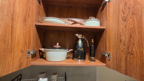 un armario de cocina con tetera y tetera en JAS Stays Studio with Free WIFI and NETFLIX, en Nanyuki