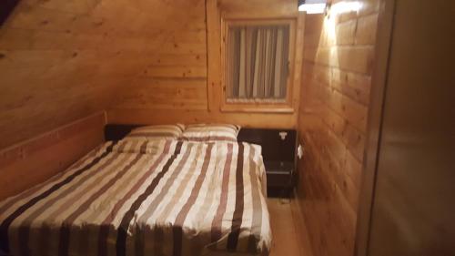 1 dormitorio con 1 cama en una habitación de madera en Holiday Home Floris, en Kopaonik